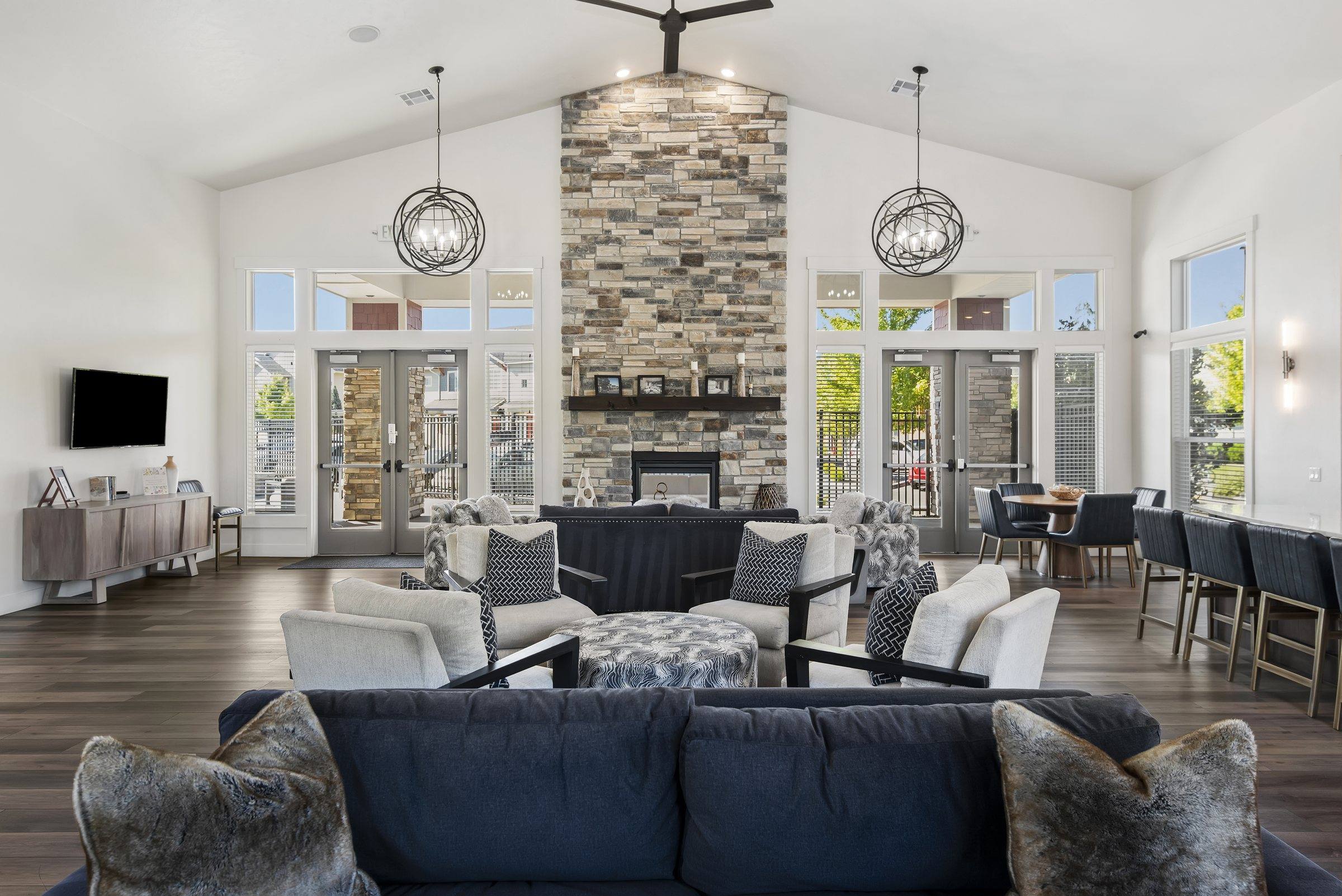 The Enclave resident clubhouse lounge with a stone fireplace and comfortable seating